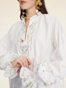 A woman wears the Social Queen Floral Embroidered Cotton Blouse with ruffled cuffs, paired with large gold earrings and a choker necklace.