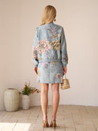 A woman with long blonde hair stands indoors on a tiled floor near potted plants, wearing the Social Queen Floral Embroidered Jacquard Jacket and holding a small handbag.
