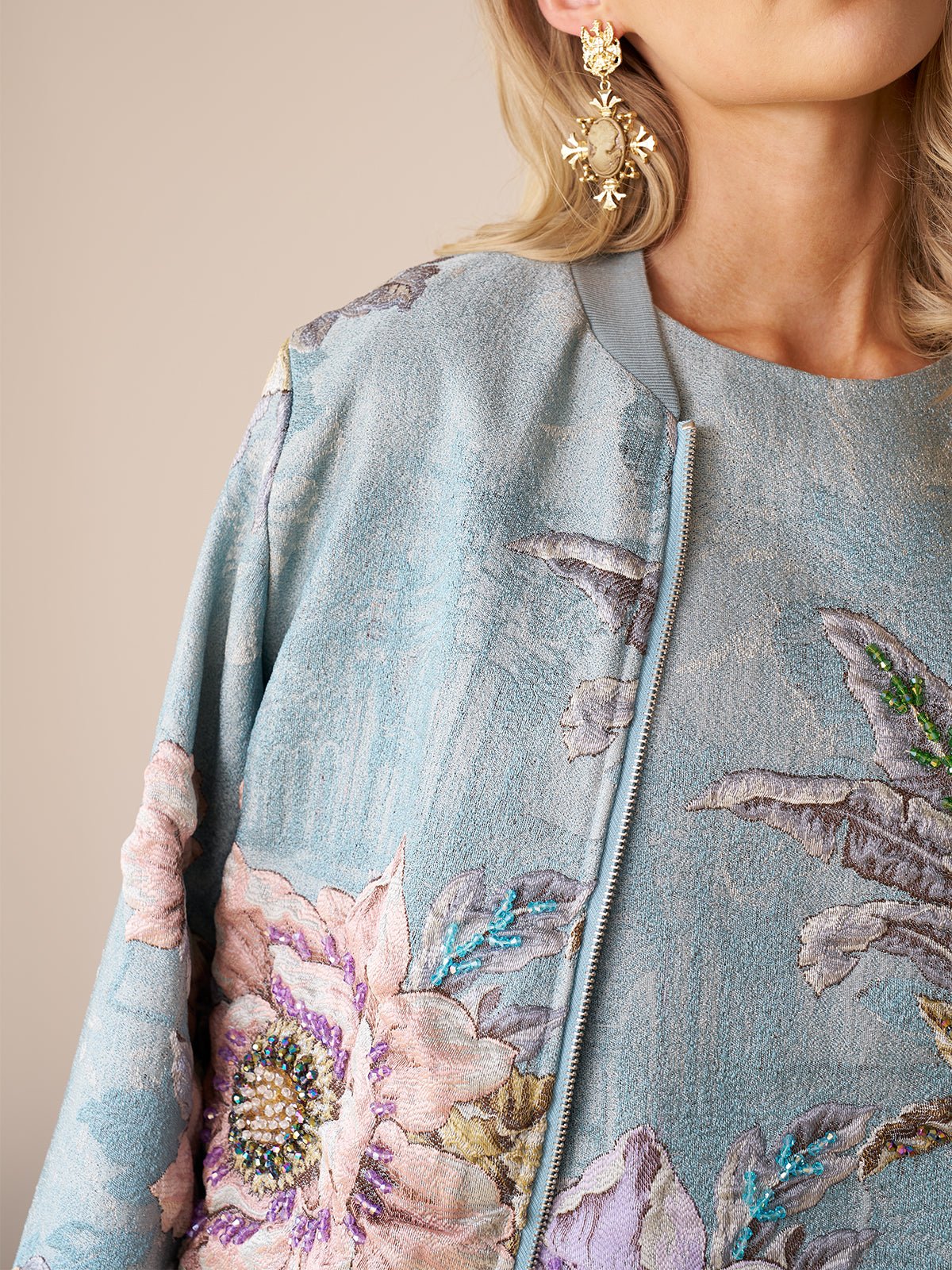 A person wearing the Social Queen Floral Embroidered Jacquard Jacket with a front zipper and large earrings—an ideal choice for wedding guests seeking elegance on any occasion.