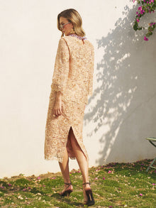 A woman in the Social Queen Floral Embroidered Lace Midi Skirt with a back slit stands on grass near a white wall, wearing sunglasses and heeled sandals.