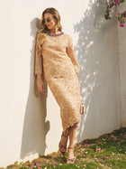 A woman in a beige Social Queen Floral Embroidered Lace Midi Skirt and sunglasses leans against a white wall outdoors, holding a clutch amid flowers and sunlight.