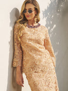 A woman in sunglasses and gold earrings wears the Social Queen Floral Embroidered Lace Top with Beaded Details, standing against a light-colored wall in sunlight.