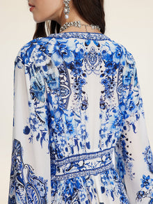 A woman seen from the back wears Social Queen's Floral Embroidered Lantern Sleeve Dress, styled with crystal jewelry.