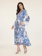 A woman wears the Social Queen Floral Embroidered Lantern Sleeve Dress with lace cuffs and silver high heels, standing against a plain light background.