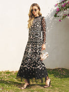 Wearing the Social Queen Floral Embroidered Mesh Dress with sheer tulle panels, sunglasses, and sandals, she stands outdoors holding a floral handbag—a stunning wedding guest look.