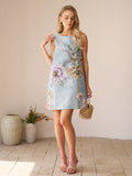 A woman stands indoors in the Social Queen Floral Jacquard Dress, featuring sleeveless design and light blue floral embroidery, holding a small woven handbag—a chic pick for a stylish wedding guest look.