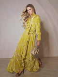 A woman stands indoors wearing the Social Queen Floral Jacquard Velvet Ruffles Dress in yellow, paired with heeled sandals and a small woven handbag.
