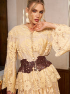 Model wearing the Social Queen Floral Lace Embroidered Blouse in yellow with flared sleeves, styled with statement earrings and a wide brown belt, posing indoors against a neutral background.