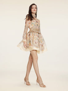 A woman in the Social Queen Floral Print Hand-Beaded Dress stands against a plain light background, styled with patterned tights and open-toe heels.