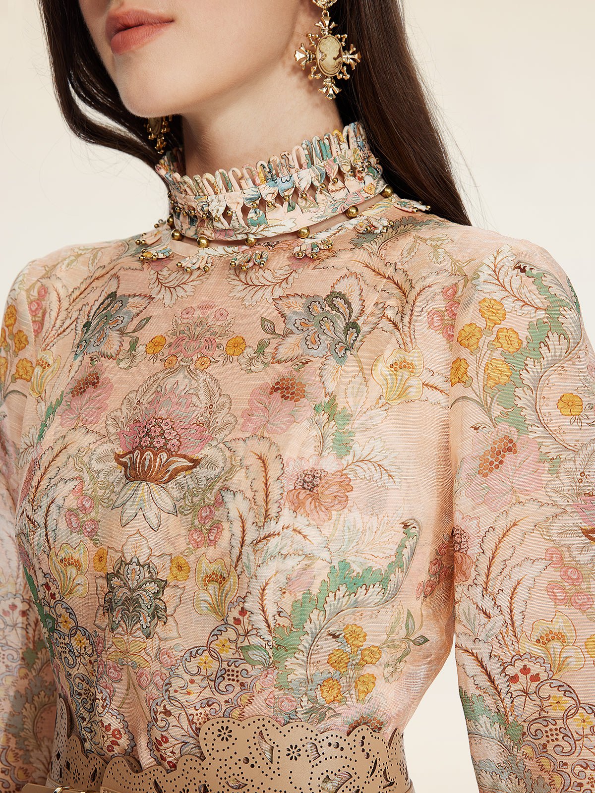 A woman wears the Social Queen Floral Print Hand-Beaded Dress, featuring a high neck, long sleeves, jacquard texture, floral embroidery, intricate beadwork, and statement earrings.
