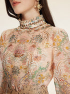 A woman wears the Social Queen Floral Print Hand-Beaded Dress, featuring a high neck, long sleeves, jacquard texture, floral embroidery, intricate beadwork, and statement earrings.