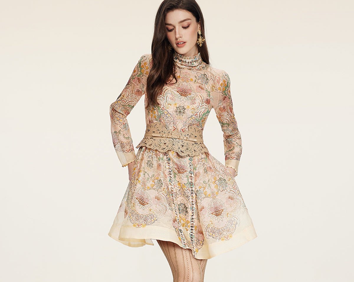 A woman models the Social Queen Floral Print Hand-Beaded Dress, featuring long sleeves, a fitted bodice, flared skirt, and ornate belt, against a plain background.
