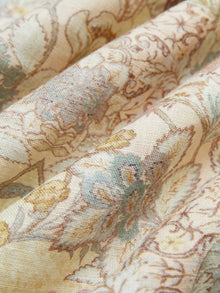 Close-up of Social Queen’s Floral Print Midi Skirt in beige linen, featuring a vintage-inspired floral pattern in soft blue, yellow, and brown tones that showcase the fabric's texture and gentle folds.