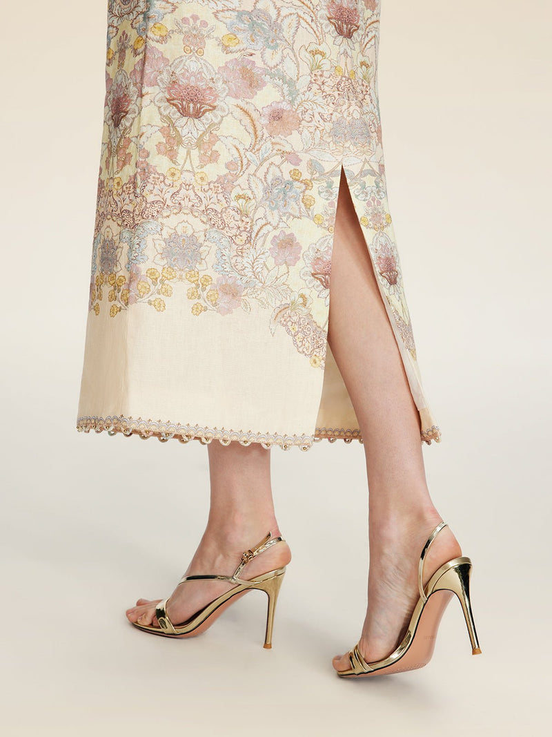 A person wears the Social Queen Floral Print Midi Skirt, featuring a high waist and side slit, paired with gold high-heeled sandals on a neutral background.