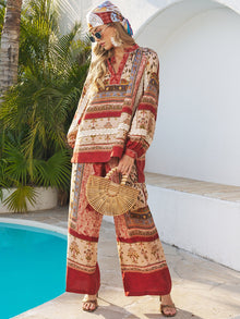 A woman by a pool wears Social Queen’s Floral Print Wide-Leg Boho Pants, paired with sunglasses, a bamboo bag, and a headscarf.