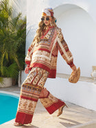 A woman wearing Social Queen’s Floral Print Wide-Leg Boho Pants strolls by a pool, pairing them with a matching top, headscarf, sunglasses, heels, and a wooden handbag.