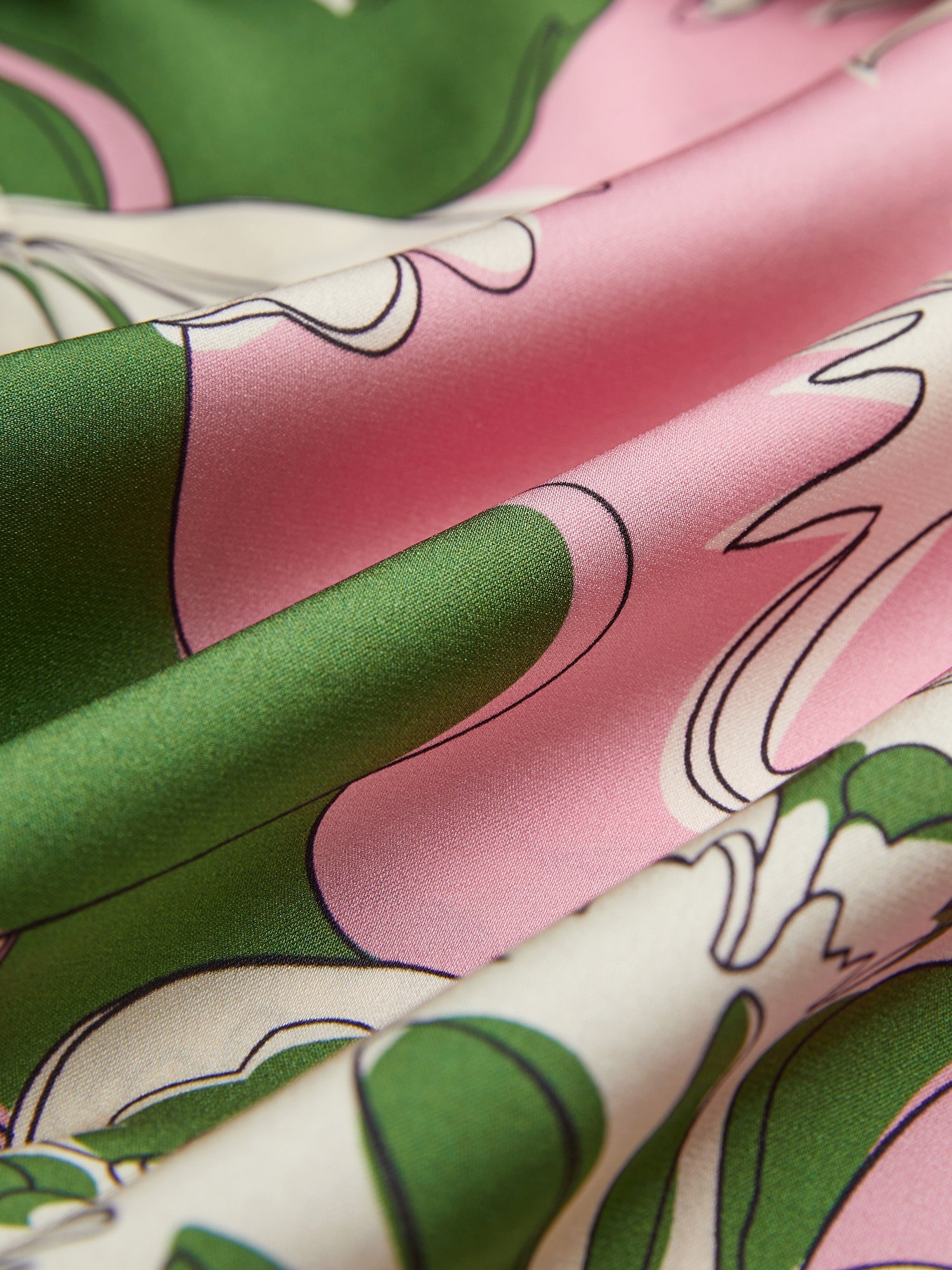 Close-up of silky fabric with green, pink, and white florals and soft folds—ideal for the Social Queen Floral Printed Silk Dress, capturing vacation elegance.