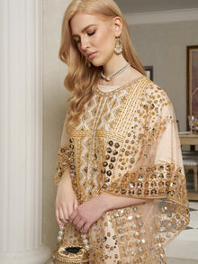 A woman with long blonde hair wears the Social Queen Gold Sequin Beaded Tulle Cape Dress with matching earrings and holds a beaded bag, standing indoors.