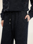 Model wears Social Queen Gradient Rhinestone Wide-Leg Pants with an elastic waist and matching hoodie, one hand in their pocket.