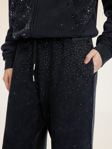 Model wears Social Queen Gradient Rhinestone Wide-Leg Pants with an elastic waist and matching hoodie, one hand in their pocket.