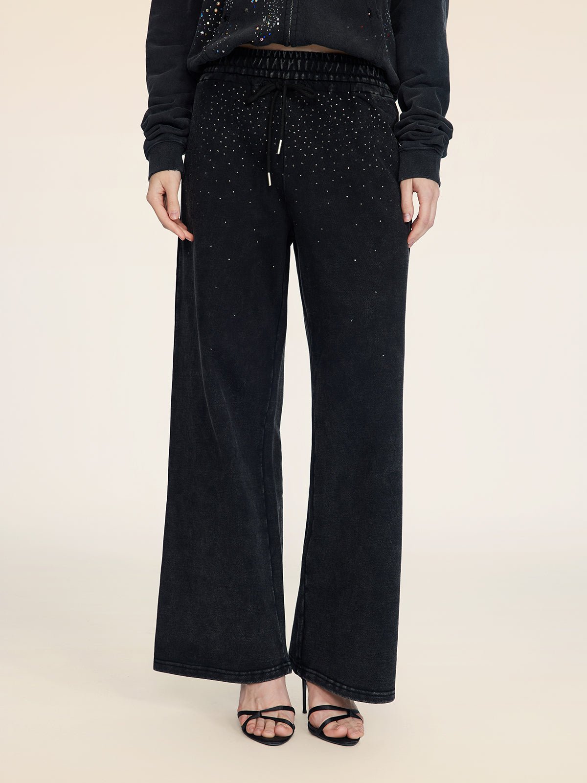 A person is shown from the shoulders down wearing Social Queen Gradient Rhinestone Wide-Leg Pants with an elastic waist, a matching black top, and black heeled sandals against a plain background.