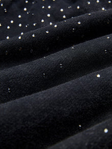 Close-up of Social Queen’s Gradient Rhinestone Wide-Leg Pants, showcasing their textured black fabric with small, shiny silver studs scattered throughout.