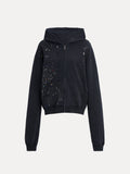 The Social Queen Hand-Applied Rhinestone Washed Hoodie is a relaxed black zip-up with a hood, side pockets, and multicolored hand-applied rhinestones scattered across the chest and sleeves.