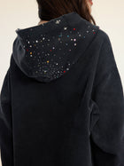 A person seen from behind wears the Social Queen Hand-Applied Rhinestone Washed Hoodie, featuring multicolored beads and hand-applied rhinestones on the hood.