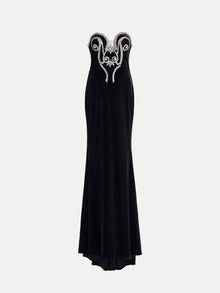 The Social Queen Hand-Applied Silver Crystal Baroque Velvet Gown is a strapless, fitted evening dress with hand-beaded silver crystal swirl details on the chest and a floor-length skirt.