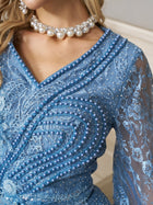 Close-up of a woman wearing the Social Queen Hand-Beaded Lace Mermaid Dress, a blue tulle gown adorned with intricate beadwork and pearls, paired with a pearl necklace.