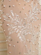 Close-up of the Social Queen Hand-Beaded Sequin Embroidered Cocktail Gown, showcasing beige fabric adorned with sequins, leaf embroidery, and pearl-like beading in a decorative arrangement.