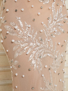 Close-up of the Social Queen Hand-Beaded Sequin Embroidered Cocktail Gown, showcasing beige fabric adorned with sequins, leaf embroidery, and pearl-like beading in a decorative arrangement.