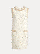 The Hand-Beaded Silk Wool Embossed Dress by Social Queen is a sleeveless cream mini dress featuring pearl trim, gold bead embellishments, two front pockets, and a round neckline.