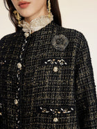 A woman wears the Social Queen Hand-Beaded Tweed Fringe Jacket, featuring ornate buttons and a decorative brooch; her face is partially visible.