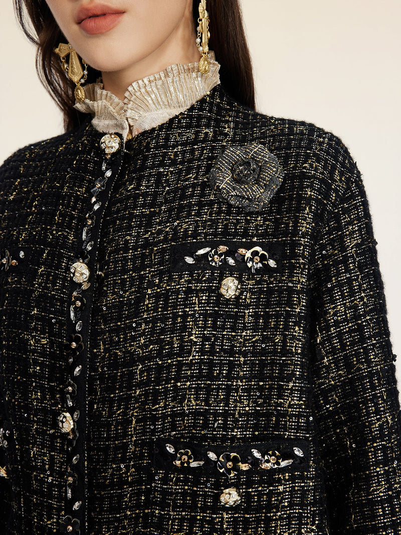 A woman wears the Social Queen Hand-Beaded Tweed Fringe Jacket, featuring ornate buttons and a decorative brooch; her face is partially visible.