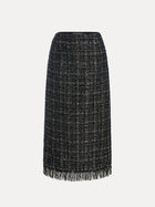 The Hand-Beaded Tweed Fringe Slit Skirt by Social Queen is a knee-length, straight-cut black-and-gold tweed skirt with hand-applied beadwork and a fringed hem, displayed against a plain white background.