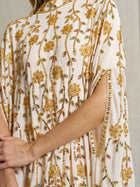 Close-up of a person wearing the Social Queen Hand-Embellished Floral Caftan Dress, a cream-colored chiffon piece featuring intricate gold embroidery, beading, and slit sleeves—perfect resort wear.