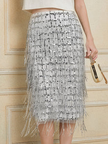A person wearing the Social Queen Hand-Embellished Sequin Fringe Skirt, holding a small gold clutch bag.