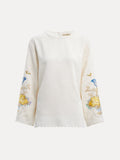 The Social Queen Hand-Embroidered Floral Jacquard Pullover features long sleeves and cream fabric with blue and yellow floral motifs hand-embroidered on the sleeves, shown against a plain white background.
