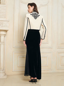 A woman stands indoors facing away, wearing the Social Queen Hand-Embroidered Silk-Wool Cropped Tweed Jacket with a long black skirt, her hair down and styled with black heels.