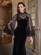 A woman in the Social Queen Hand-Sewn Crystal Velvet Feather Mermaid Gown stands indoors, holding a gold clutch and looking at the camera.