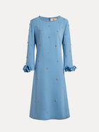 The Social Queen Handcrafted Beaded Floral A-Line Dress features a knee-length blue design with long sleeves, hand-beaded floral embellishments, and ruffled cuffs, shown against a white background.