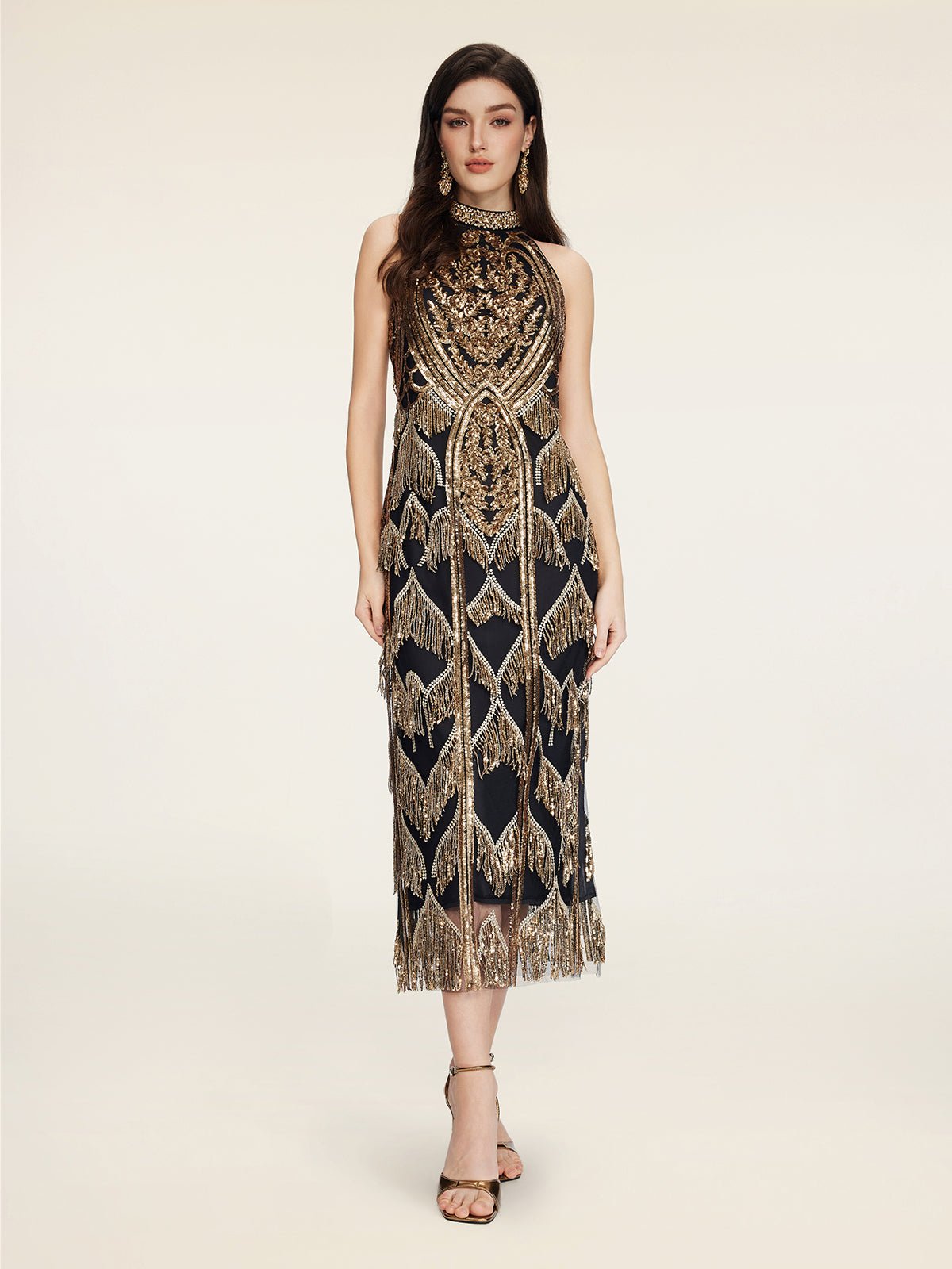 A woman models the Social Queen Handcrafted Fringe Sequin Halter Gown, featuring hand-applied sequins and geometric patterns, against a plain light background.