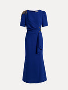 The Handcrafted Gold-Trimmed Slit Dress by Social Queen features gold accents on one shoulder and waist, short sleeves, and a draped fishtail silhouette in sapphire blue.