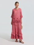 A woman wears the Social Queen 3D Floral Embroidered 100% Silk Ruffle Blouse, featuring floral embroidery and ruffle details, paired with a small purse and sandals against a plain background.
