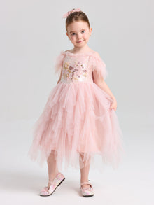 A young girl wears the Social Queen Girls Floral Sequin Tulle Dress with matching pink shoes, posing against a plain light background.