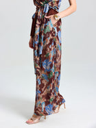 A person wearing Social Queen Floral Print Wide-Leg Pants and beige high-heeled sandals, showcasing effortless vacation style against a plain light background.