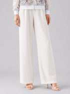A person wearing Social Queen’s Casual Wide-Leg Pants, featuring a mid-high rise and lyocell-linen blend, paired with open-toe high heels, stands against a plain background, with only the lower half of their body visible.