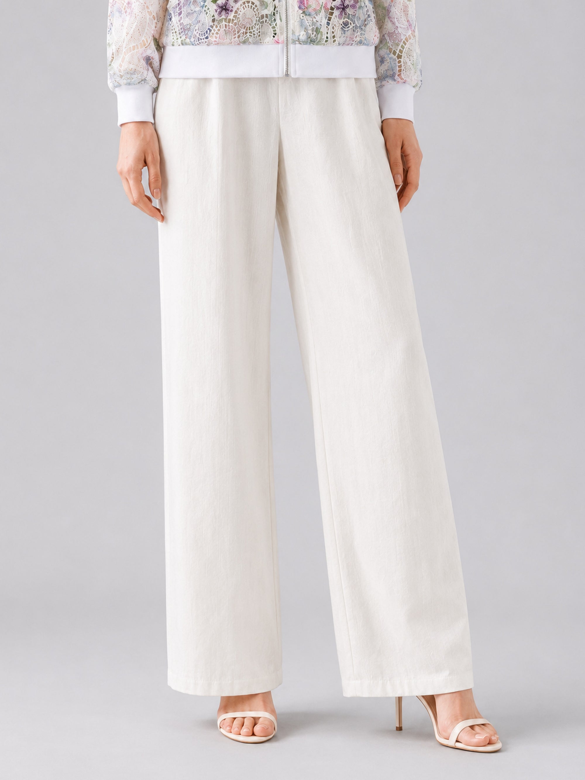 A person wearing Social Queen’s Casual Wide-Leg Pants, featuring a mid-high rise and lyocell-linen blend, paired with open-toe high heels, stands against a plain background, with only the lower half of their body visible.