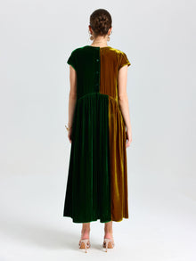 A woman faces away wearing the Social Queen Colorblock Silk Velvet Shift Dress in green and brown with short sleeves, button-back detail, and nude heels.